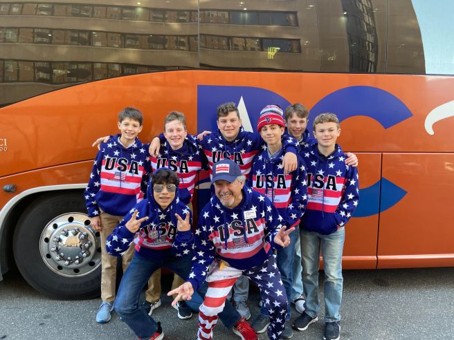 A School Tours of America DC Tour Host takes a group photo with students all in matching USA gear.