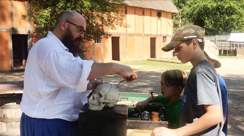 Students look on in awe at a demonstration of colonial tools from the living museum at Jamestown Settlement