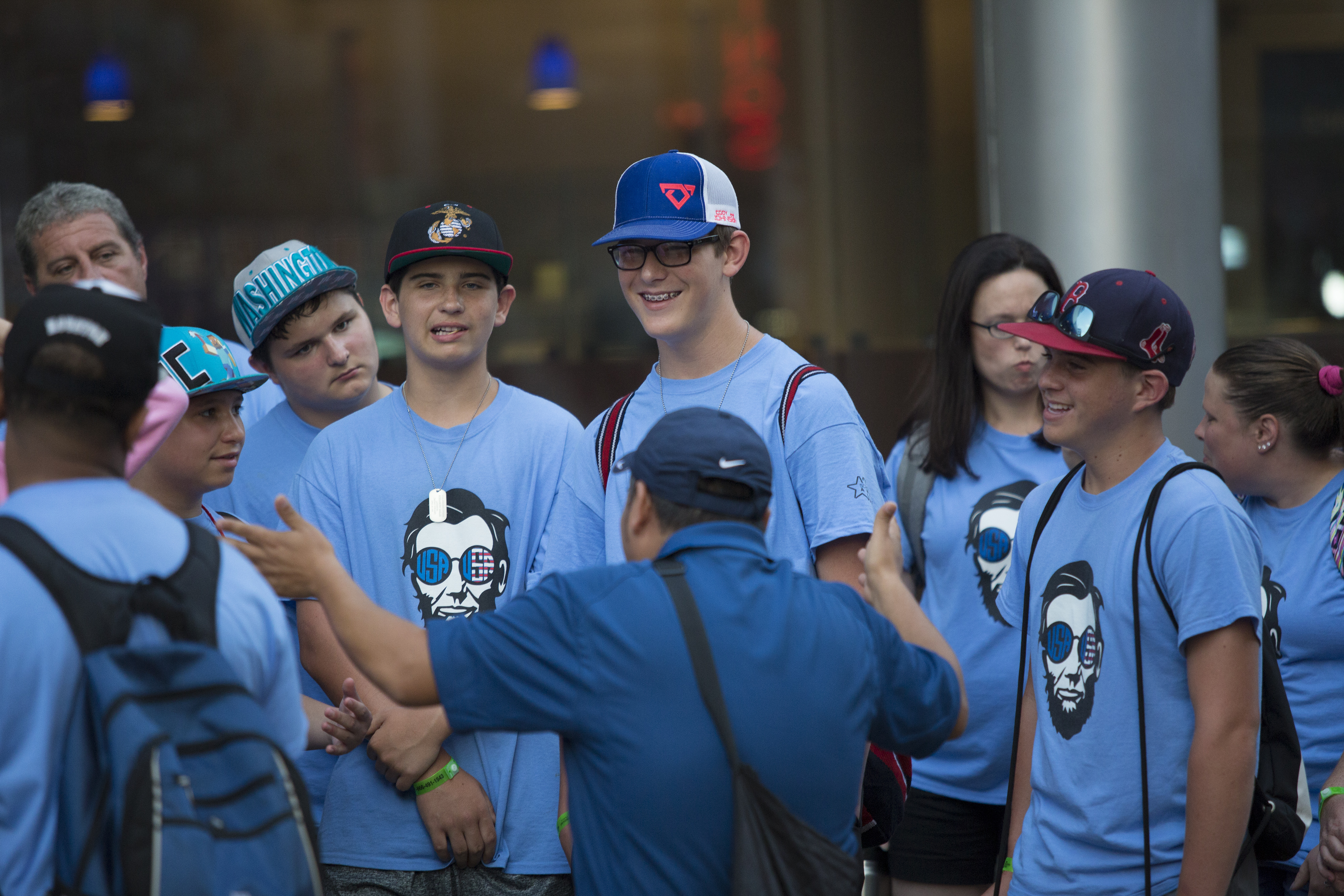 A School Tours of America New York City Tour Guide takes a selfie with a group of students in front of the Wall Street Bull